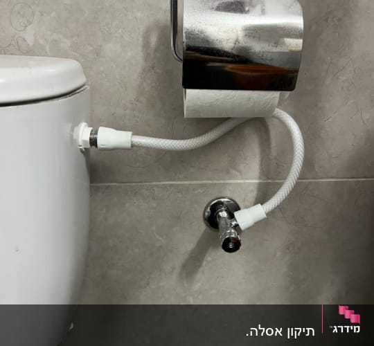 צינור מחובר לשירותים עם ברז מתכת